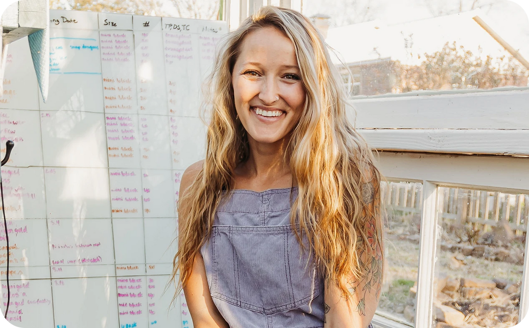 Jill standing in front of a whiteboard with notes, smiling outdoors.